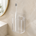 Clear adhesive wall-mounted toothbrush cup holding one white electric toothbrush