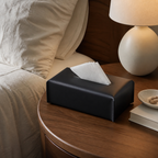 Black leather-look tissue box cover on a walnut bedside table