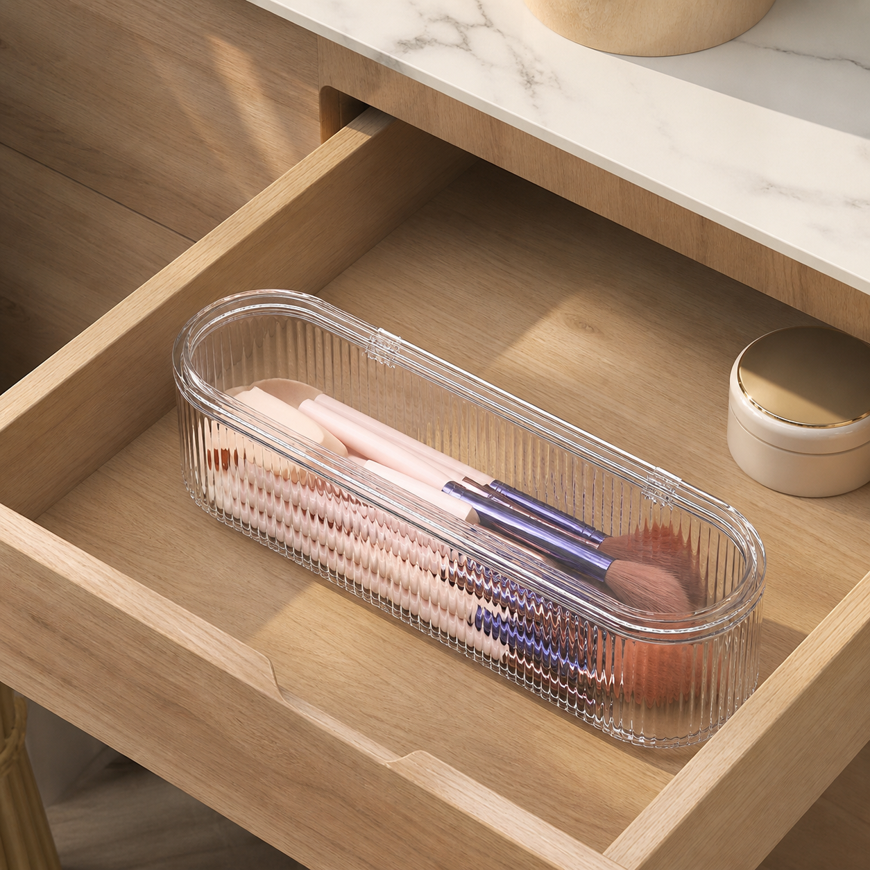 Closed clear makeup brush organizer stored inside a warm wood vanity drawer