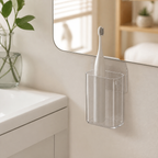 Clear wall-mounted toothbrush cup with one electric toothbrush beside a bathroom mirror