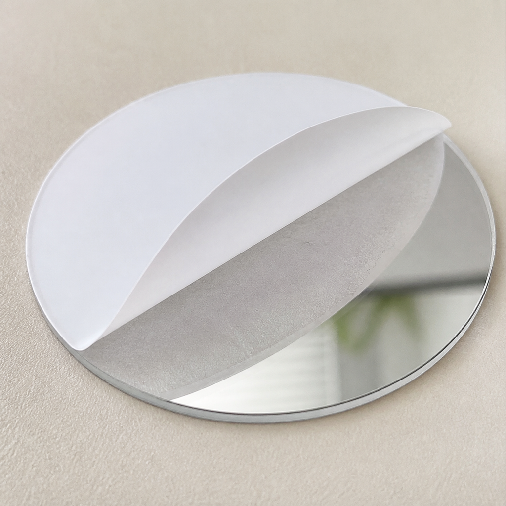 Close detail of a round acrylic mirror sticker with protective film half peeled