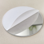 Close detail of a round acrylic mirror sticker with protective film half peeled