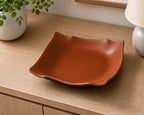 Brown smooth leather-look catchall tray on a wood surface