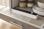 Black kitchen wrap dispenser with cutter on a kitchen shelf