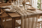 Khaki gauze table runner styled on a rectangular oak dining table with ceramic place settings