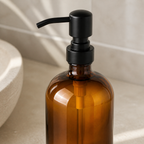 Close detail of the matte-black pump on an amber glass soap dispenser