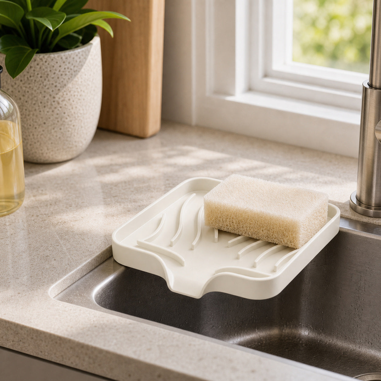 Cozy Haven Self-Draining Sink Caddy in Rice White on a kitchen sink edge
