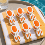 Orange 6-piece beach towel clips on a folded towel