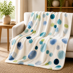 Cozy Haven Watercolor Dot Throw Blanket draped over a sofa with blue and green watercolor dots